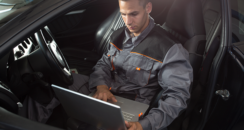 Mechanic with a laptop in car