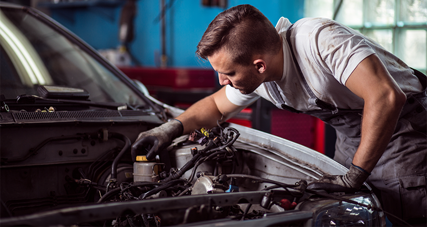 Mechanic working in car engine space